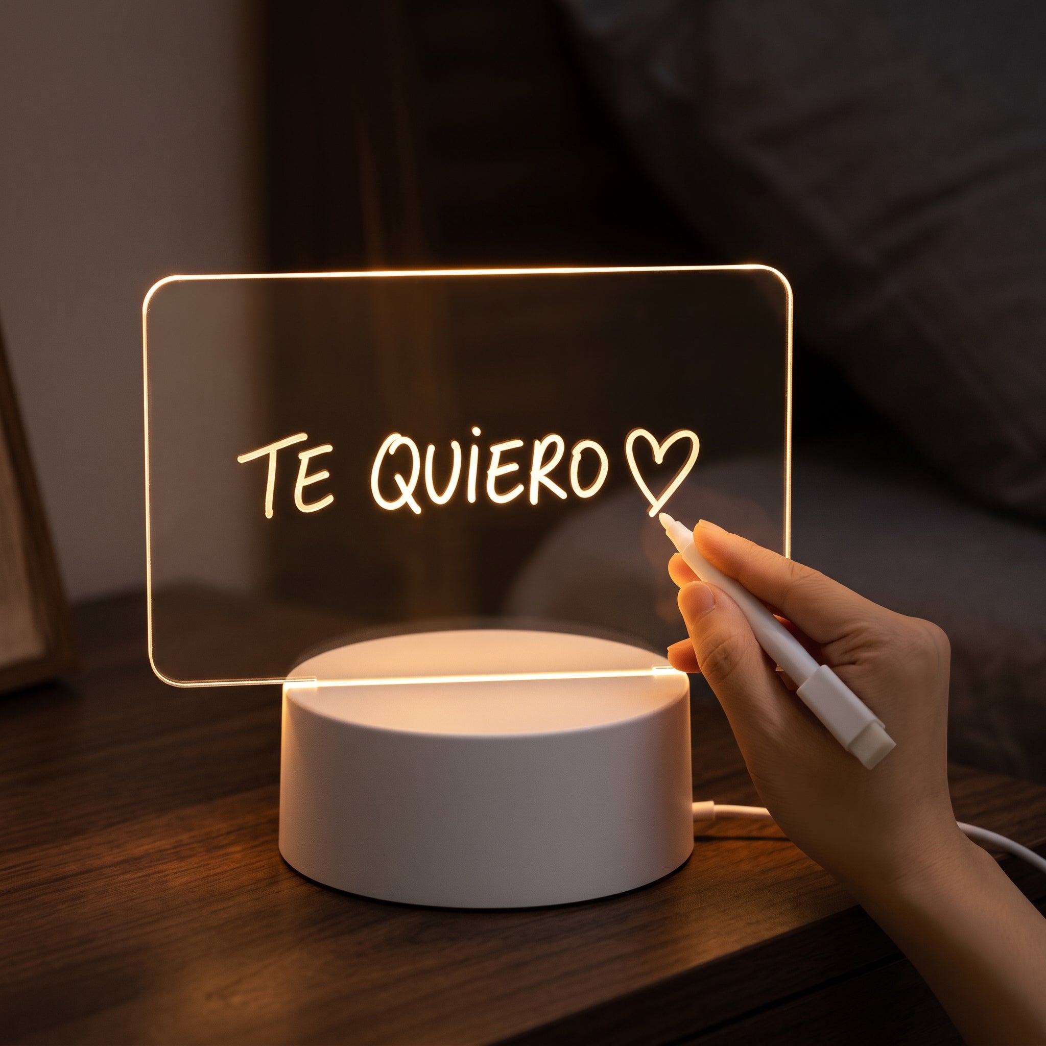 Mano escribiendo «Te quiero» en la lámpara de notas encendida